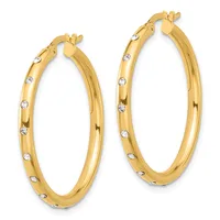 A pair of gold hoop earrings with diamond accents evenly spaced around the outer surface, shown from the front.