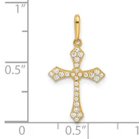 A gold cross pendant with cubic zirconia stones set throughout, displayed next to a ruler showing it measures approximately three-quarters of an inch in height.