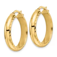 A pair of polished gold hoop earrings with textured surfaces on one side, shown from the front against a white background.
