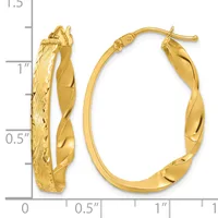 A pair of twisted gold hoop earrings with textured and polished surfaces, displayed against a measurement scale showing they are approximately one inch in length.