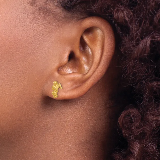 A person wearing a small gold textured hoop earring in their earlobe, shown in profile against their neck and shoulder.
