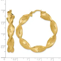 Gold twisted hoop earrings with a textured finish, shown next to a ruler measuring approximately 2 inches in length.