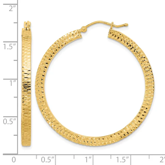 Gold textured hoop earrings displayed next to a ruler showing they measure approximately 1.5 inches in diameter.