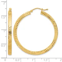 Gold textured hoop earrings displayed next to a ruler showing they measure approximately 1.5 inches in diameter.