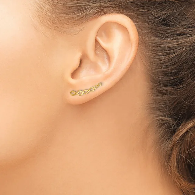 A gold curved bar earring with a series of small linked oval shapes runs horizontally across the earlobe of a person shown in profile.