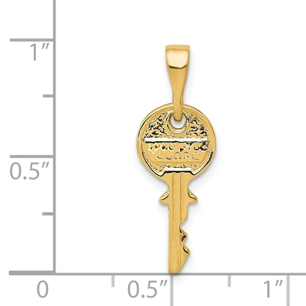 A gold key pendant with decorative circular head and serrated shaft, shown against a measurement scale indicating approximately one inch in length.