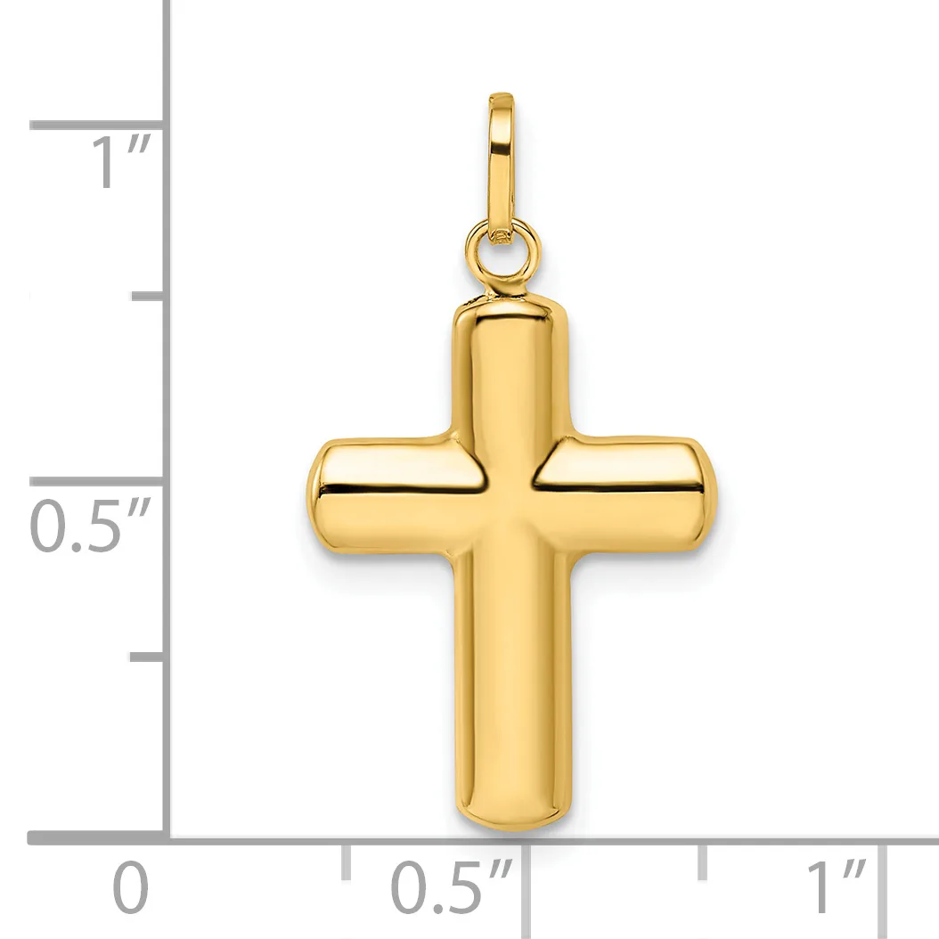 A polished gold cross pendant with rounded edges and a small loop at the top, shown next to a measurement scale indicating approximately one inch in height.