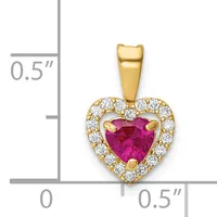 Gold heart pendant with a faceted ruby center stone surrounded by a halo of round white diamonds, shown next to a measurement scale indicating approximately 0.5 inches in height and width.