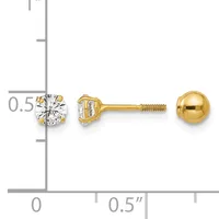 Two yellow gold stud earrings with screw backs displayed next to a ruler, one featuring a round clear gemstone and one a polished gold ball.