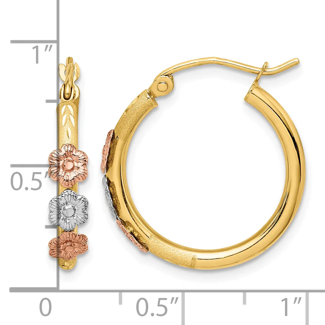 A pair of gold hoop earrings with decorative flower charms in rose and white gold, shown next to a measurement scale.