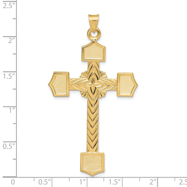 Gold cross pendant with textured rectangular terminals on the arms and a chevron-patterned shaft, displayed against a ruler showing approximately 2.25 inches in height.