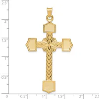 Gold cross pendant with textured rectangular terminals on the arms and a chevron-patterned shaft, displayed against a ruler showing approximately 2.25 inches in height.
