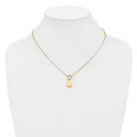 A gold-toned necklace with a delicate chain featuring a small circular connector and a smooth teardrop-shaped pendant, displayed on a white mannequin bust.