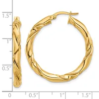 Pair of gold twisted hoop earrings with posts and backs, displayed against a measurement scale showing approximately 1.5 inches in length.