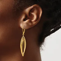 A gold-toned elongated oval drop earring with parallel ridged detailing hangs from a hook on a person's earlobe.