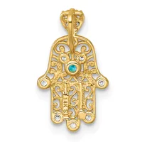 Gold filigree hamsa hand pendant with turquoise stone in center and white crystal accents throughout, displayed against a white background.