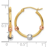 A pair of gold hoop earrings with rose gold and white gold accents and a measurement scale showing approximately one inch in length.