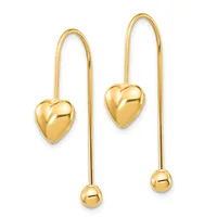 Pair of gold threader earrings featuring polished heart charms on the left earring and a small spherical bead on the right earring, suspended from long curved wires.