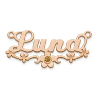 Rose gold nameplate pendant with ornate floral scrollwork on either side and a small round yellow gemstone at the center bottom.