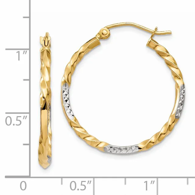A pair of gold hoop earrings with a twisted texture and rhodium-plated accents, displayed next to a measurement scale showing approximately one inch in diameter.