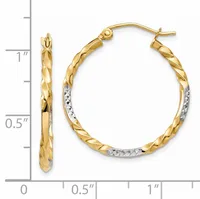 A pair of gold hoop earrings with a twisted texture and rhodium-plated accents, displayed next to a measurement scale showing approximately one inch in diameter.