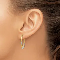 A person wearing two-tone gold and silver hoop earrings shown from the side with their ear and dark hair visible.