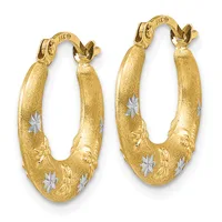 A pair of gold oval hoop earrings with a brushed finish, decorated with white star inlays and embossed leaf designs, displayed against a white background.