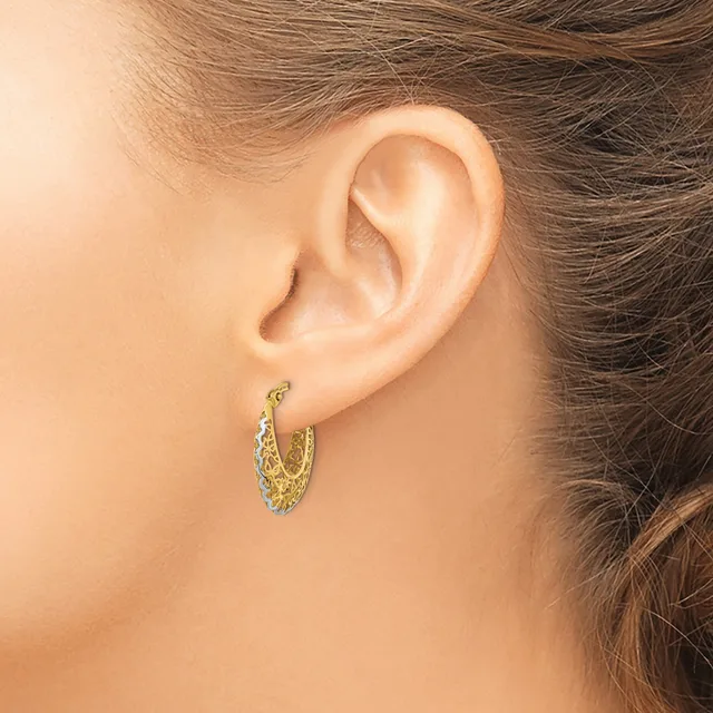 A person wearing a textured gold-toned hoop earring is shown from the side, displaying the earring against their ear and neck.