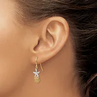A person wearing a dangling earring featuring a starfish top in silver with a golden pineapple-shaped pendant below, shown from the side view of their ear.