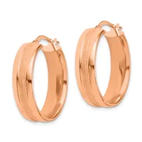 A pair of rose gold hoop earrings with textured and polished finish bands, displayed against a white background.