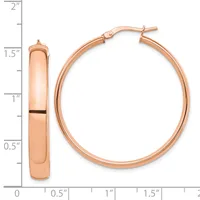 Rose gold hoop earrings displayed next to a measurement ruler showing the earrings are approximately 1.5 inches in diameter with a polished finish.