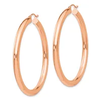 A pair of polished rose gold hoop earrings with a smooth, rounded profile and hinged closures, displayed side by side.