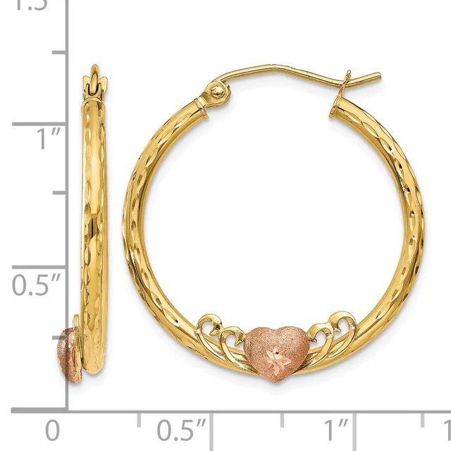 Pair of gold hoop earrings with textured finish and rose gold heart charms, shown against a ruler measuring approximately one inch in diameter.