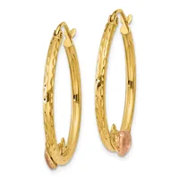 Pair of gold hoop earrings with textured and polished surfaces and rose gold accents at the bottom, shown against a white background.