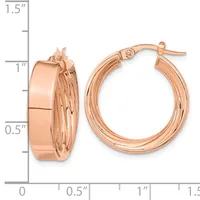Rose gold hoop earrings with a polished finish and textured inner surface, shown next to a measurement ruler indicating approximately one inch in diameter.