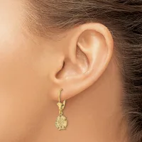A woman wearing a gold-toned leverback earring with a textured round pendant hangs from her earlobe.
