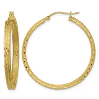 A pair of gold hoop earrings with a textured surface and small black speckled details, shown from front and side views.