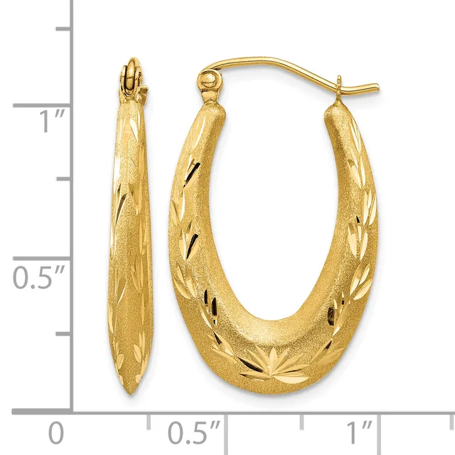 Pair of gold oval hoop earrings with textured surface and diagonal line details, displayed against a measurement scale.