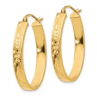 A pair of yellow gold hoop earrings with decorative etched detailing on the lower half and polished surfaces on the upper half, shown from the front.