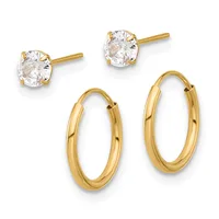 Two pairs of gold earrings: stud earrings with round clear cubic zirconia stones and hinge-back oval hoop earrings.