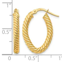 A pair of gold twisted oval hoop earrings with post and clutch backs, shown next to a ruler measuring approximately one inch in length and half an inch in width.