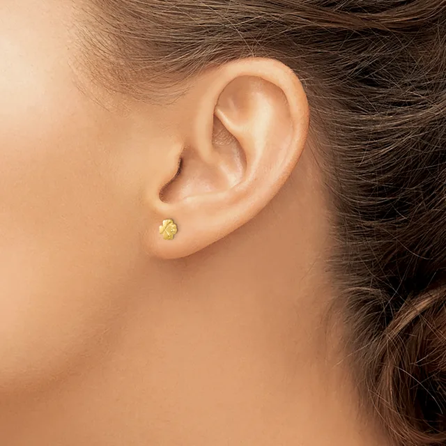 A person wearing a small round gold stud earring in their pierced earlobe, shown in profile view.