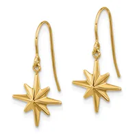 A pair of gold star-shaped drop earrings with elongated points, suspended from thin wire hooks.
