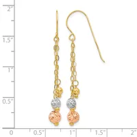 Pair of gold tricolor dangle earrings with chain and textured sphere beads, shown against a ruler measuring approximately two inches in length.