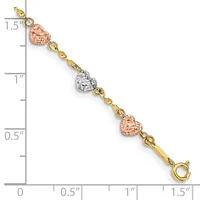 A gold bracelet with alternating rose gold and white textured heart charms connected by small gold beads, displayed against a measurement ruler.