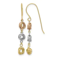 Pair of dangling earrings with rose gold, silver, and yellow gold textured knot charms connected by jump rings on curved ear wires.