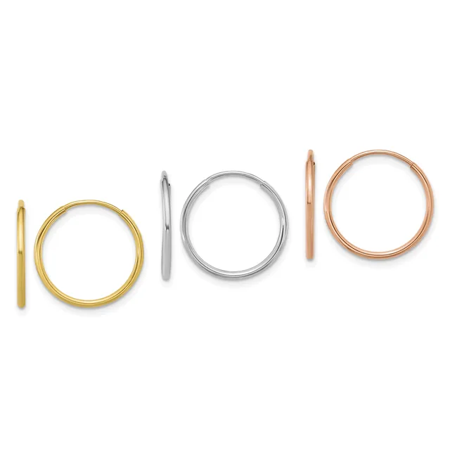 Six simple metal rings arranged in a row, including gold, silver, and rose gold circular and tubular bands of varying widths.