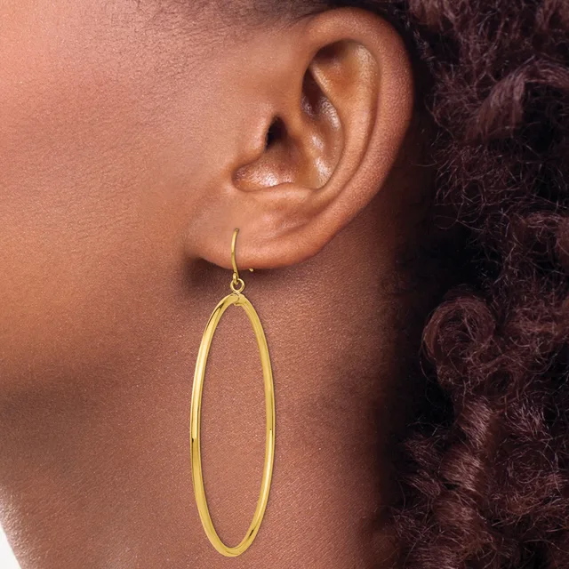 A person wearing a long oval-shaped gold hoop earring hanging from a hook, shown from the side profile view.