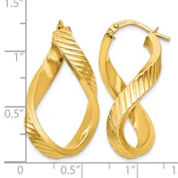 Pair of twisted gold hoop earrings with diagonal ribbed texture on one side, displayed next to a ruler showing approximately one inch in length.