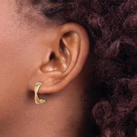 A person wearing a curved gold hoop earring with a small yellow gemstone accent, shown in profile against dark curly hair.